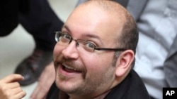 FILE - Jason Rezaian, an Iranian-American correspondent for the Washington Post, smiles as he attends a presidential campaign of President Hassan Rouhani in Tehran, April 11, 2013.