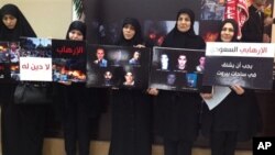 Lebanese women whose relatives were killed at the Iranian embassy attack in Beirut last November hold placards show portraits of their victims, Beirut, Jan. 3, 2014.