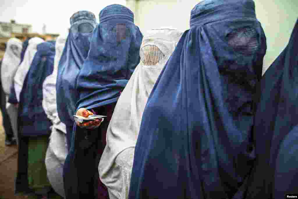 Afghan women stand in line while waiting for their turn to vote at a polling station in Mazar-i-sharif. Voting was peaceful during the first few hours of the presidential election, with only isolated attacks on polling stations.