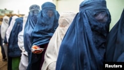 FILE - Afghan women stand in line while waiting for their turn to vote at a polling station in Mazar-i-sharif.