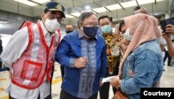 Menhub Budi Karya Sumadi (kiri) dan Menristek Bambang Brodjonegoro berbincang dengan penumpang di Stasiun Senen, Rabu (3/2). (Foto: Humas Kemenhub)