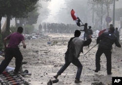 Manifestants attaquant la police à coups de pierres et de bombes incendiaires, près de la Place Tahrir (16 déc. 2011)