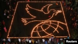 FILE - People light lamps as they make a formation of a peace symbol on the eve of Diwali, the Hindu festival of lights, in Chandigarh, India, October 18, 2017. (REUTERS/Ajay Verma)