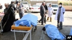 Bodies of bomb attack victims are seen outside a hospital in Tikrit, some 150 km (95 miles) north of Baghdad, 18 Jan 2011