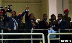 Presiden Eritrea Isaias Afwerki bersama PM Ethiopia Abiy Ahmed melambaikan tangan ke arah para pendukung mereka saat menghadiri konser di Millennium Hall di Addis Ababa, Ethiopia, 15 Juli 2018.