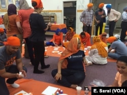 Kamal Saini, son of a victim of the Oak Creek Shootings, paints with the color orange, symbolizing the color hunters wear to protect themselves in the woods.