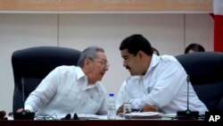 El presidente de Cuba, Raúl Castro, conversa con el mandatario venezolano Nicolás Maduro durante la cumbre del ALBA sobre ébola en La Habana.