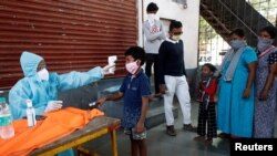 အိႏၵိယမွာ ကုိ႐ိုနာဗုိင္းရပ္စ္ ပ်ံ႕ႏွံ႔မႈ ကာကြယ္ႏုိင္ေရး ကေလးငယ္တဦးကို ကုိယ္အပူခ်ိန္ တုိင္းတာစစ္ေနတဲ့ျမင္ကြင္း။ (ေမ ၂၉၊ ၂၀၂၀)