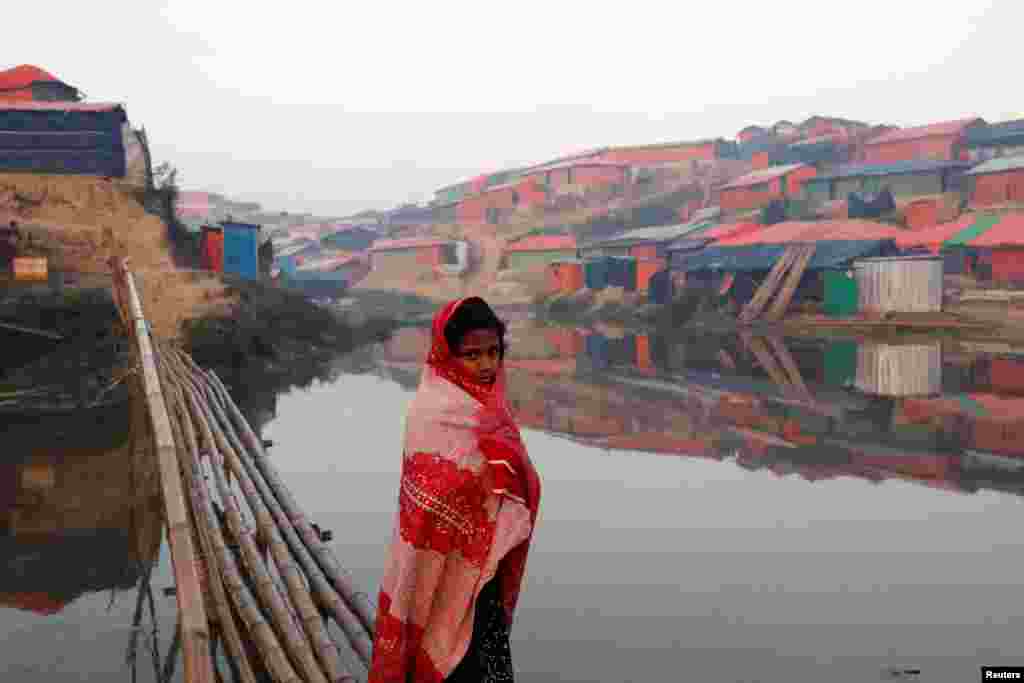 قدم زدن یک دختر آواره روهینگیا از مقابل برکه ای که در کمپ پناهندگان بنگلادش واقع شده است. &nbsp;