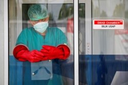 Seorang petugas bersiap melakukan tes PCR Covid-19 di tengah meningkatnya kasus positif dalam pandemi corona di Jakarta, Indonesia, 24 November 2020. REUTERS/Willy Kurniawan