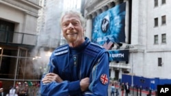 Sir Richard Branson, founder of Virgin Galactic, poses for a photo outside the New York Stock Exchange before his company's IPO, Monday, Oct. 28, 2019. (AP Photo/Richard Drew)