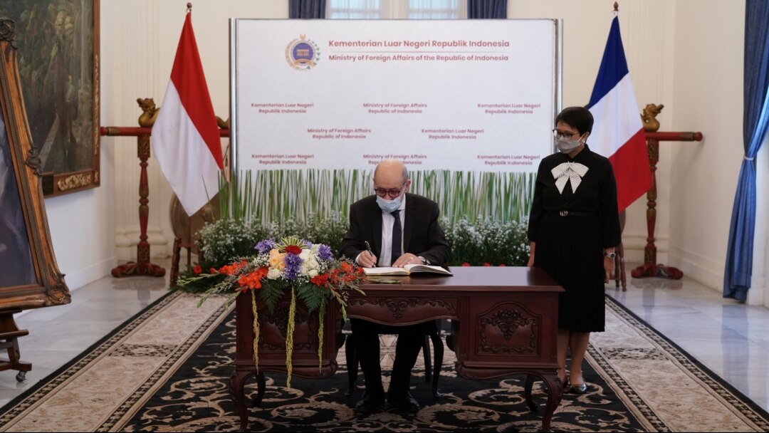Menlu Prancis Jean-Yves Le Drian menandatangani buku tamu yang disaksikan Menlu Retno Marsudi sebelum pertemuan mereka di Jakarta, 24 November 2021. (Foto: Courtesy Kemenlu via Reuters)