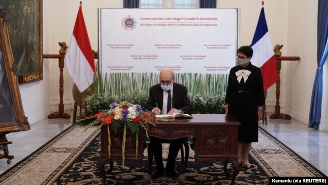 Menlu Prancis Jean-Yves Le Drian menandatangani buku tamu yang disaksikan Menlu Retno Marsudi sebelum pertemuan mereka di Jakarta, 24 November 2021. (Foto: Courtesy Kemenlu via Reuters)