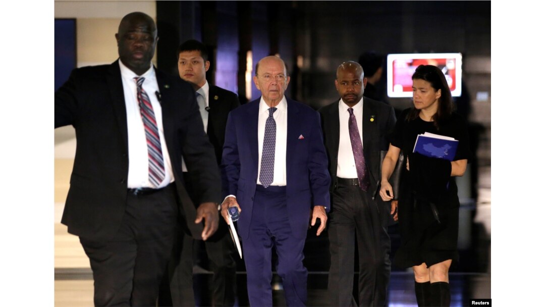 FILE - U.S. Commerce Secretary Wilbur Ross (C), a member of the U.S. trade delegation to China, leaves a hotel in Beijing, China, May 3, 2018.