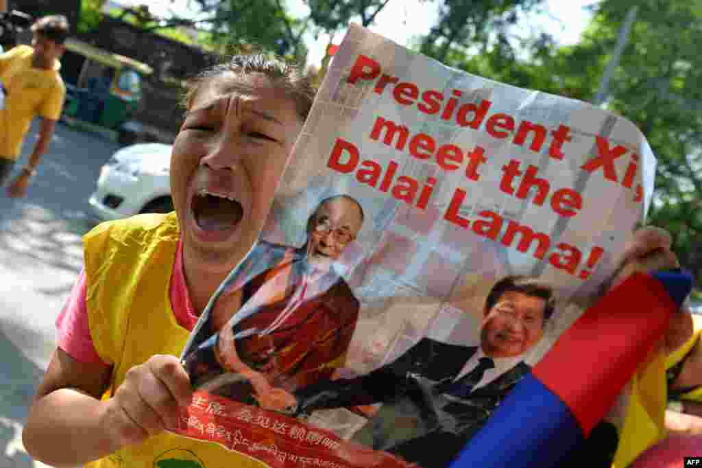 Exiled Tibetan youth hold banners and shout slogans during a protest against a visit to India by Chinese President Xi Jinping, outside a hotel in New Delhi.
