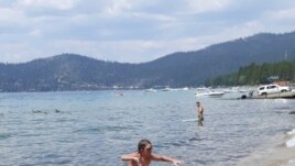 James leaves the water after completing a 12-hour swim across the entire length of Lake Tahoe. (AP Photo/Jillian Savage)