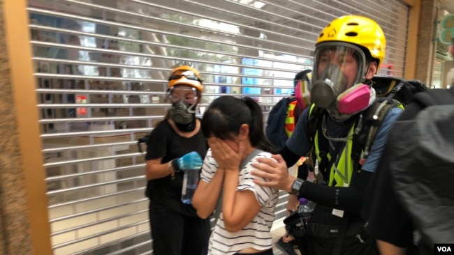 有市民不知道警方在德福花园商场施放催泪弹驱散示威者，被催泪烟波及，双眼刺痛，由示威者护送到安全地点 (摄影：美国之音汤惠芸)