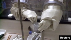 FILE - A scientist examines a package for anthrax spores.