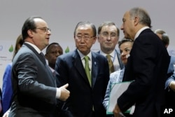 From left, French President Francois Hollande, U.N. Secretary-General Ban Ki-moon and Foreign Affairs Minister and President-designate of COP21 Laurent Fabius, right speak together at the end of a plenary session, Dec. 12, 2015.