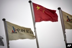 FILE - SinoSteel Corp. and Chinese flags fly outside of the company's headquarters in Beijing, China, Nov. 18, 2015. "There is a stiff competition between China and Japan vying for deals in third countries," an experts says of competing economic ambitions between the two.