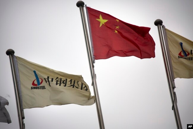 FILE - SinoSteel Corp. and Chinese flags fly outside of the company's headquarters in Beijing, China, Nov. 18, 2015. "There is a stiff competition between China and Japan vying for deals in third countries," an experts says of competing economic ambitions between the two.
