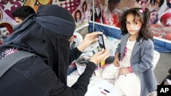 Nadia Abudllah photographing a young girl during the uprising in Sana'a, Yemen, February 20, 2012.