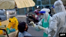 Arhiva, ilustracija - Medicinski radnici uzimaju bris za testiranje na prisustvo koronavirusa, na ulici u Maku, 5. juna 2020. (Photo by Ahmed SHURAU / AFP)
