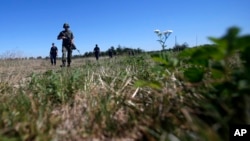 FILE - Serbian army soldiers and border police officers patrol near the border between Serbia and Bulgaria, not far from the border crossing Vrska Cuka, some 250 km (155 miles) southeast of Belgrade, Serbia, Monday, Aug. 15, 2016.