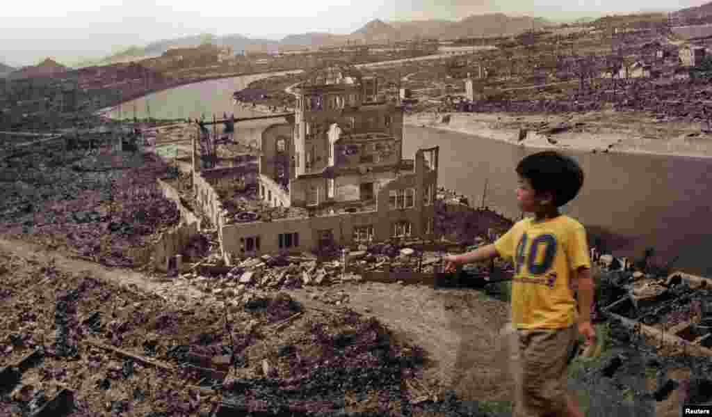 A boy looks at a huge photograph showing Hiroshima city after the 1945 atomic bombing, at the Hiroshima Peace Memorial Museum, Japan, August 6, 2007. 