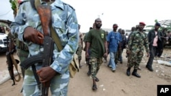 A man known as Commander Bauer, the chief of a group of fighters which calls itself the "invisible commandos", walks with his men in northern Abidjan's Abobo district. Fighting in Ivory Coast's main city is spreading and the death toll from a power strugg