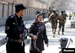 An Afghan woman seeks for her relative at the site of a suicide bombing in Kabul, March 21, 2018.