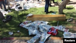 The body of a victim, covered by newspapers, lies next to a coffin after an explosion in Suruc in the southeastern Sanliurfa province, Turkey, July 20, 2015. 