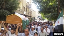 Residents carry the coffin of Muhammad Mousa, whom protesters say was killed by forces loyal to Syria's President Bashar al-Assad, during his funeral in Yabroud near Damascus July 21, 2012.