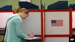 A woman casts her vote during primary voting in Durham, N.C., May 8, 2018.