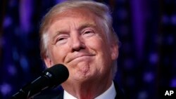 FILE - President-elect Donald Trump smiles as he arrives to speak at an election night rally, November 9, 2016.