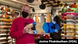 Co-owner of Uncle Funkys Boards, Jeff Gaites, holds a Surfskate, a skateboard, inside his shop in Manhattan, New York March 25, 2021.