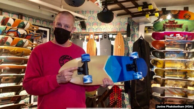 Co-owner of Uncle Funkys Boards, Jeff Gaites, holds a Surfskate, a skateboard, inside his shop in Manhattan, New York March 25, 2021.