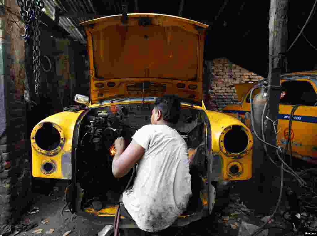 ایک شخص اپنی گاڑی کی مرمت میں مصروف۔