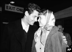 FILE - Singer Eddie Fisher and his fiancee, actress Debbie Reynolds, have eyes only for each other at Idlewild Airport, April 19, 1955, in New York on arriving by plane from England.