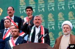 FILE - Hadi al-Amiri, center, speaks to his followers during his political block campaign rally in Baghdad, Iraq, May 7, 2018.