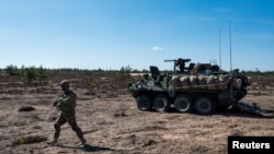 Un soldat de l'armée américaine et un véhicule blindé Stryker participent à l'exercice "Arrow 16" avec l'armée finlandaise à Niinisalo, en Finlande, le 4 mai 2016.