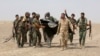 FILE - G-7 leaders are expected to discuss efforts to defeat the Islamic State. Here, Iraq's Shi'ite paramilitaries and Iraqi security forces hold an Islamist State flag pulled down in Anbar province, May 26, 2015.