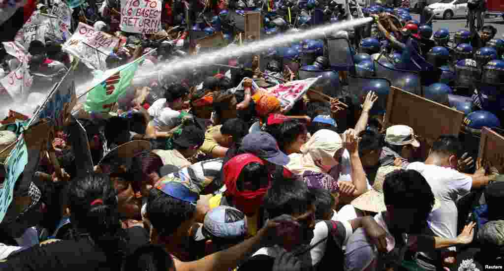 Police use a water cannon on &quot;Bayan Muna&quot; (My Country First) activists who tried to march to the U.S. embassy as they protest a state visit by President Barack Obama in Manila, Philippines. Hundreds of activists gathered near the U.S. embassy, protesting a new defence agreement which they say underscores unequal relations between the Philippines and the United States.
