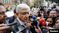 FILE - Mexican President-elect Andres Manuel Lopez Obrador talks to journalist as he arrives to a meeting with his new cabinet in Mexico City, Mexico, July 7, 2018.