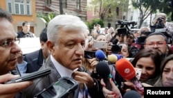 FILE - While still Mexico's president-elect, Andres Manuel Lopez Obrador talks to journalists in Mexico City, Mexico, July 7, 2018. A group of Mexican journalists, columnists and commentators have since demanded that Lopez Obrador, now president, stop harassing critical media.