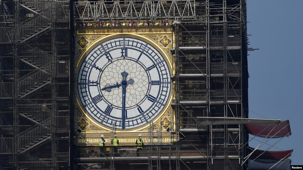 FILE - Workers stand on scaffolding underneath one of the clock faces on the Elizabeth Tower, more commonly known as Big Ben, as renovation works continue at the Houses of Parliament, London, Britain, September 6, 2021. (REUTERS/Toby Melville/File Photo)