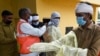 印度法里达巴德的市政工作人员穿上防护服将要去给一个居民区喷药消毒以防范新冠病毒的蔓延。（2020年4月15日）