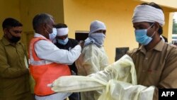 印度法里達巴德的市政工作人員穿上防護服將要去給一個居民區噴藥消毒以防範新冠病毒的蔓延。（2020年4月15日）