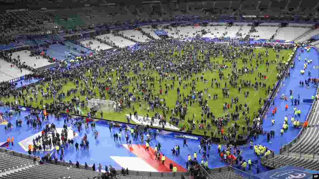 Spectators invade the pitch of the Stade de France stadium after the international friendly soccer between France and Germany, in Saint Denis, outside Paris, Nov. 13, 2015.
