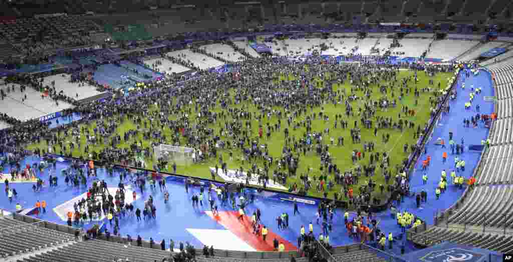 Spectators invade the pitch of the Stade de France stadium after the international friendly soccer France against Germany, in Saint Denis, outside Paris, Nov. 13, 2015.